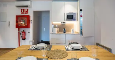 a dining room with a table and a kitchen at Airhostel Barcelona Airport 24h in El Prat de Llobregat