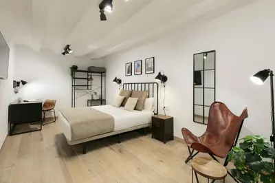 a bedroom with a bed and a desk and a chair at KeyFamily Loft Las Ramblas in Barcelona
