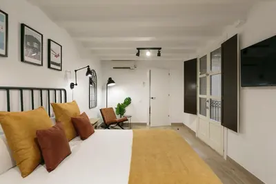 a bedroom with a large white bed with brown pillows at KeyFamily Loft Las Ramblas in Barcelona