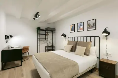 a white bedroom with a bed and a desk at KeyFamily Loft Las Ramblas in Barcelona