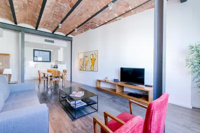 a living room with a couch and a tv at Decô Apartments Barcelona-Diagonal in Barcelona