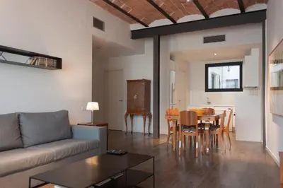 a living room with a couch and a table at Decô Apartments Barcelona-Diagonal in Barcelona
