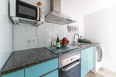 a kitchen with blue cabinets and a sink at Terrassa de Mar Apartment in Masnou