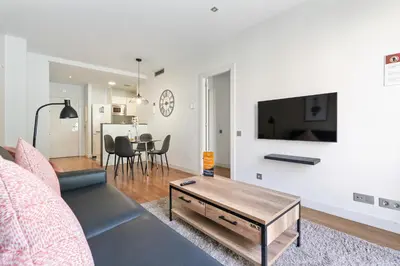 a living room with a couch and a tv on a wall at Sensation Sagrada Familia in Barcelona