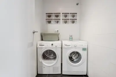 a white laundry room with a washer and dryer at Sensation Sagrada Familia in Barcelona