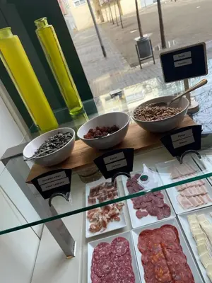 a display case with different types of meats and desserts at Aura Park Aparthotel Fira Barcelona in Hospitalet de Llobregat