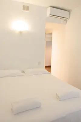 a white bed with two white towels on it at Sweet BCN Three Bedroom Apartment in Barcelona