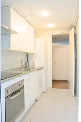 a kitchen with white cabinets and a sink at Sweet BCN Three Bedroom Apartment in Barcelona