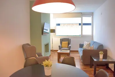 a living room with a table and chairs at Sweet BCN Three Bedroom Apartment in Barcelona