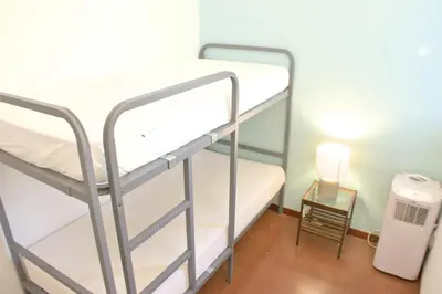 a room with two bunk beds and a small table at Sweet BCN Three Bedroom Apartment in Barcelona
