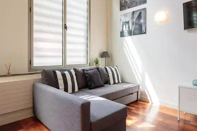a living room with a couch and a window at Modern and Trendy Duplex next to Paseo de Gracia in Barcelona