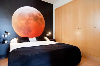 a bedroom with a bed with an orange moon on the wall at AB Park Güell-Gaudi in Barcelona