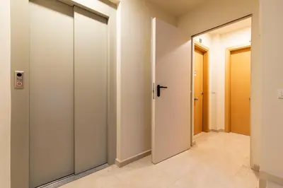 a corridor with white walls and doors in a hallway at AB Park Güell-Gaudi in Barcelona