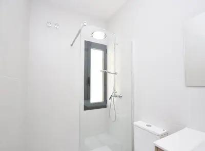 a white bathroom with a shower and a mirror at La casa del Pi · La casa del Pi · House in the city, next to Barcelona and beach in Badalona