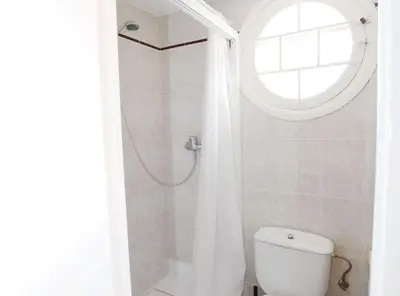 a bathroom with a shower and a toilet with a window at La casa del Pi · La casa del Pi · House in the city, next to Barcelona and beach in Badalona