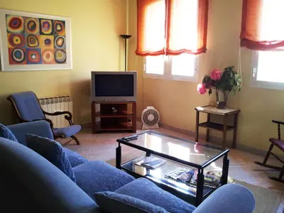 a living room with a blue couch and a tv at Apartament Mare Nostrum in Sitges