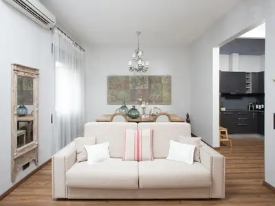 a living room with a white couch with pillows at BCN Rambla Catalunya Apartments in Barcelona