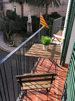 a wooden table with a flag on a balcony at Sitges Apartment in Sitges
