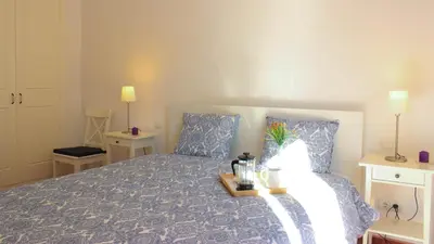 a bedroom with a bed with a blue comforter at Sitges Apartment in Sitges