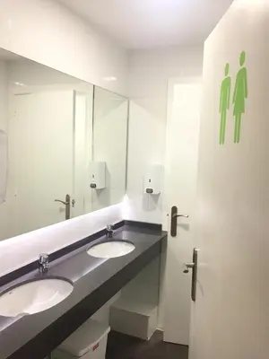 a public bathroom with two sinks and a mirror at Alberguinn in Barcelona