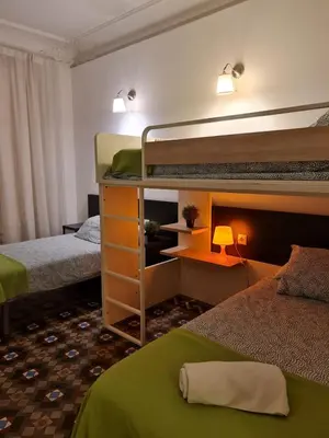 a room with two bunk beds and a desk with a lamp at Big Apartment Barcelona Gran via in Barcelona
