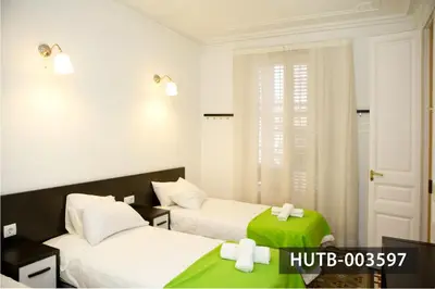 a bedroom with two beds with green and white sheets at Big Apartment Barcelona Gran via in Barcelona