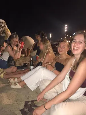 a group of people sitting on the beach at night at Itaca Hostel in Barcelona