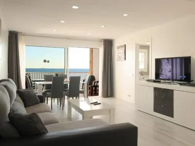 a living room with a couch and a table with a television at fantasticas vistas a mar in Pineda de Mar