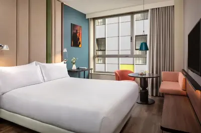 a hotel room with a large white bed and a window at NH Barcelona Diagonal Center in Barcelona