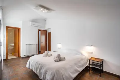 a bedroom with a white bed with towels on it at Residential Tourist Apartments in Caldes d'Estrac