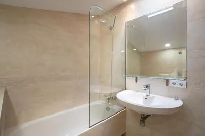 a bathroom with a sink and a glass shower at Residential Tourist Apartments in Caldes d'Estrac