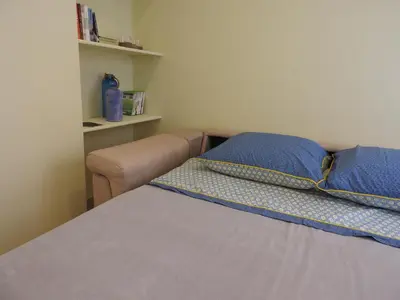 a bed with blue pillows and a couch in a room at Heart of Sitges in Sitges