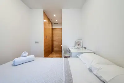 a white bedroom with a bed and a desk at Plaza Europa Fira Gran Via in Hospitalet de Llobregat