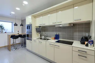 a kitchen with white cabinets and a sink and a counter at Plaza Europa Fira Gran Via in Hospitalet de Llobregat