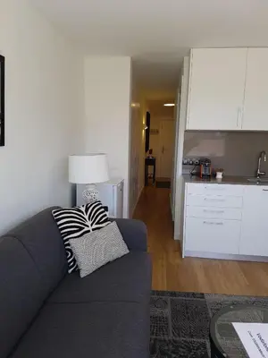 a living room with a couch and a kitchen at Sitges - Apartamento in Sitges
