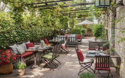 an outdoor patio with tables and chairs and plants at Primero Primera in Barcelona
