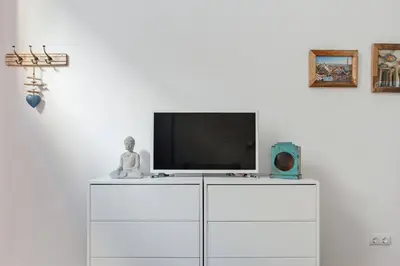 a tv on top of a white dresser at Stylish Apartment with Terrace for Couple or Family in Barcelona