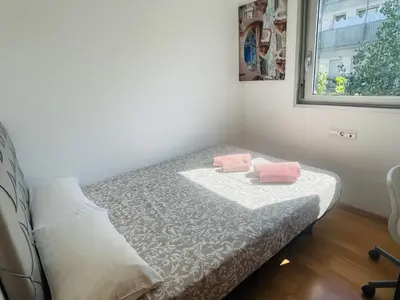 a small bed in a room with two pink pillows on it at Forum Beach in Sant Adria de Besos