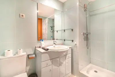 a white bathroom with a sink and a toilet at Forum Beach in Sant Adria de Besos