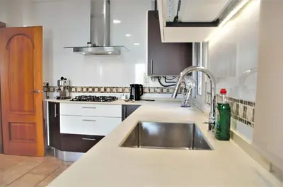 a kitchen with a sink and a stove at VILLA SOFIA CALELLA in Calella