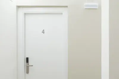 a white door with a silver handle on a wall at Hostal Oliveta in Barcelona