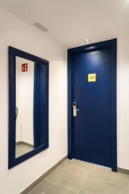 a blue door with a sign on it next to a mirror at Sea Hostel Barcelona in Barcelona