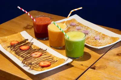 a table with two plates of food and two drinks at Sea Hostel Barcelona in Barcelona
