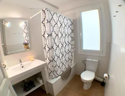 a bathroom with a sink and a toilet and a window at Apartments Gaudi Barcelona in Barcelona