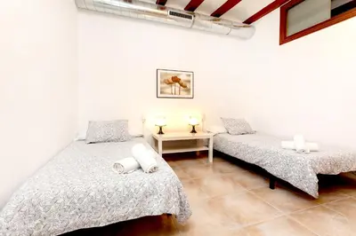 a room with two beds and a table with two lamps at Apartments Gaudi Barcelona in Barcelona