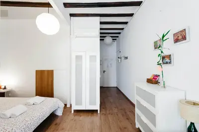 a bedroom with white walls and a bed and wooden floors at Apartments Gaudi Barcelona in Barcelona