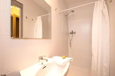 a white bathroom with a sink and a shower at Apartments Gaudi Barcelona in Barcelona