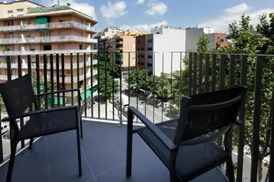 two chairs on a balcony with a view of a city at Fisa Rentals Les Corts Apartments in Barcelona