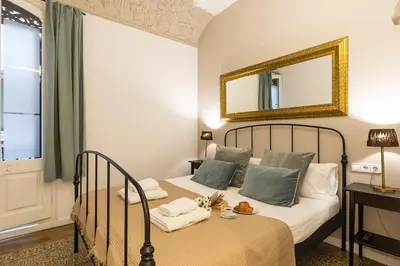 a bedroom with a bed with a mirror on the wall at Central Suites Barcelona in Barcelona