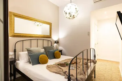 a bedroom with a bed with yellow pillows at Central Suites Barcelona in Barcelona